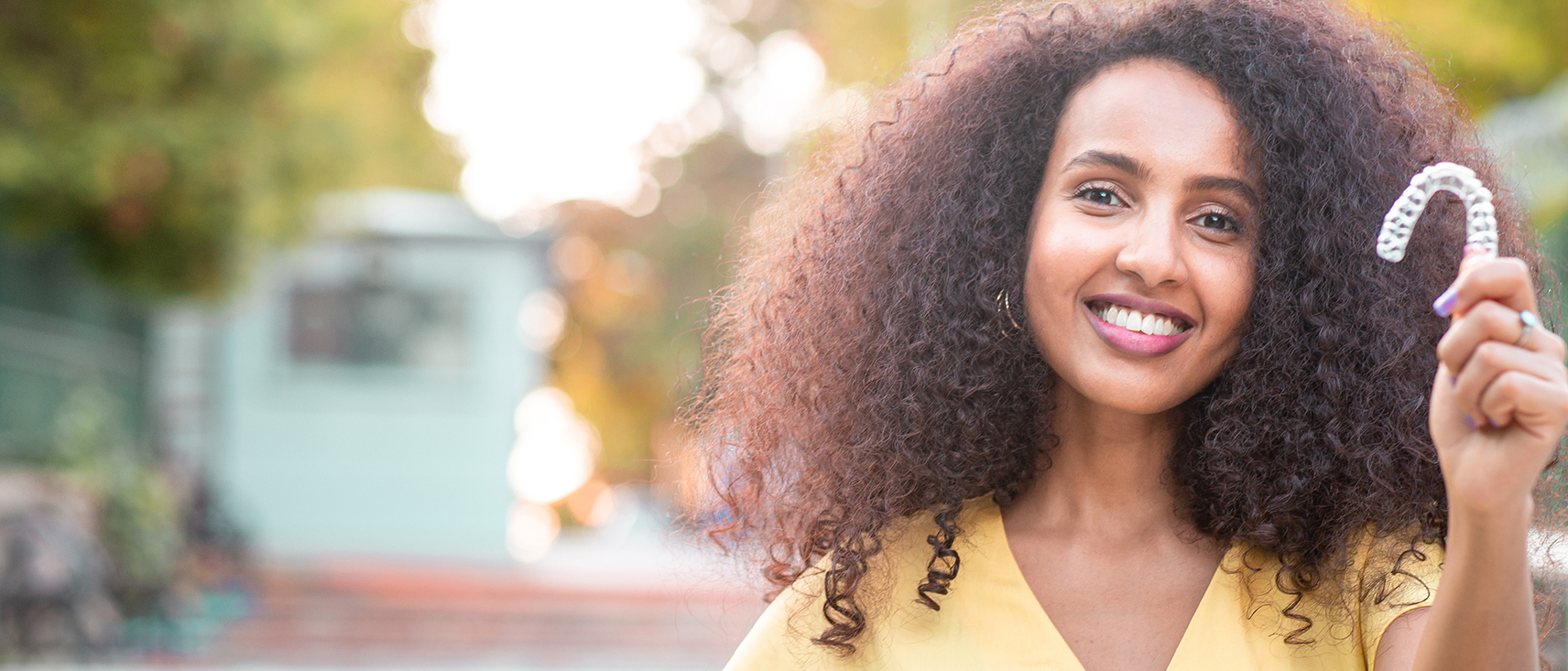 woman holding invisalign