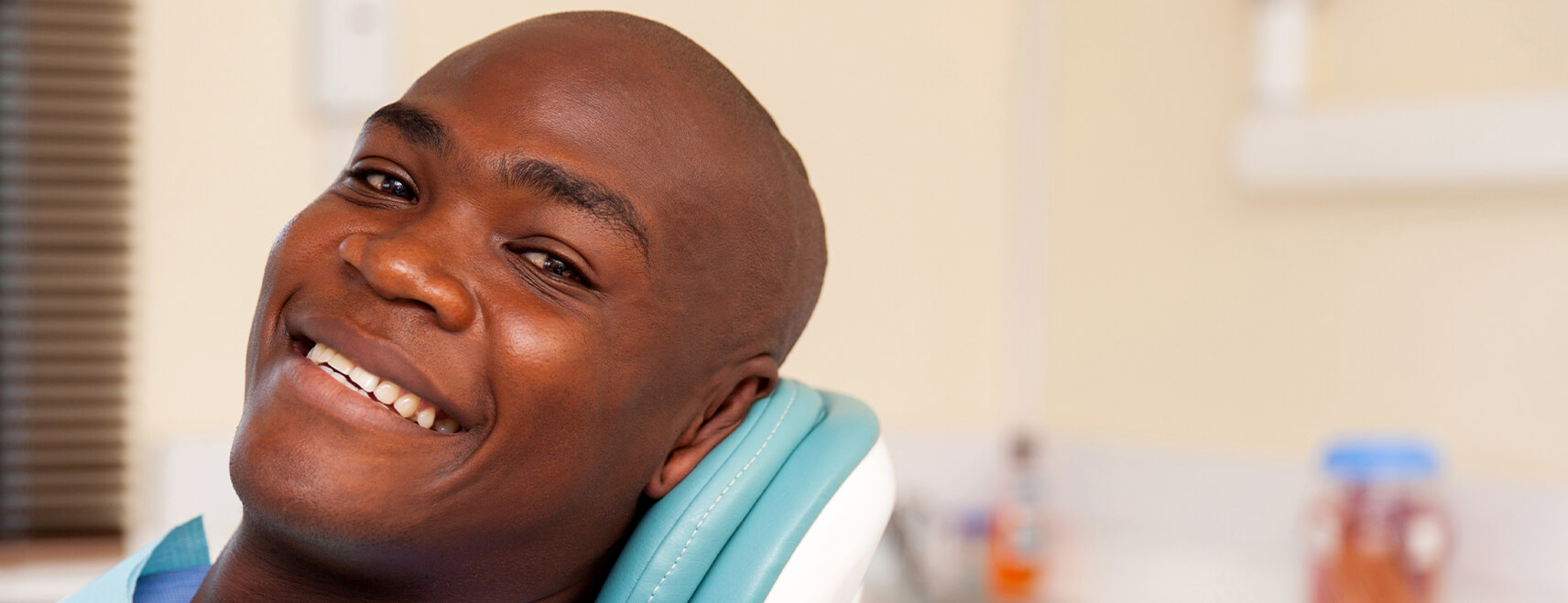 smiling man sitting in a dental chair